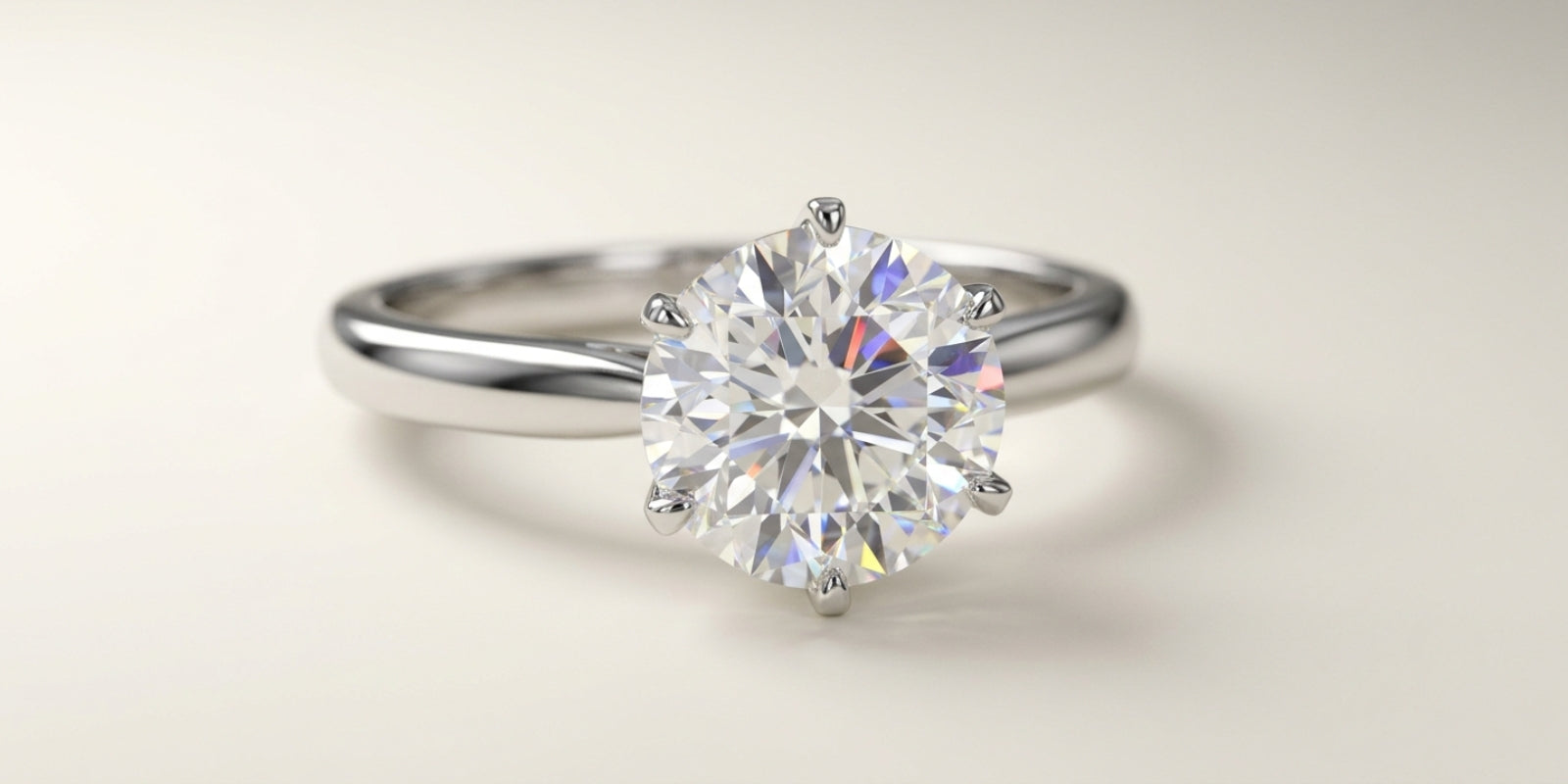 Close-up of a round brilliant lab-grown diamond solitaire ring showing crisp white brilliance and subtle rainbow fire flashes.